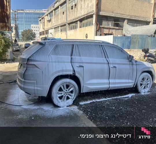 רכב מכוסה בקצף שטיפה בחניון פתוח